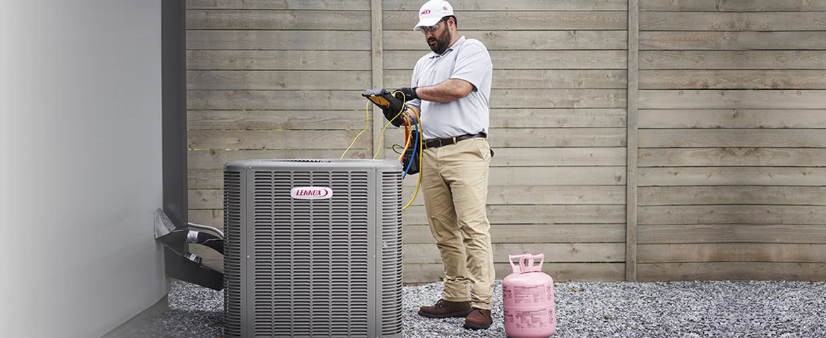 Authorized Lennox dealer checks refrigerant levels on a residential air conditioning unit.