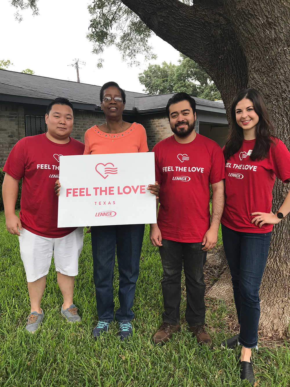 Four people holding a "Feel the Love" sign